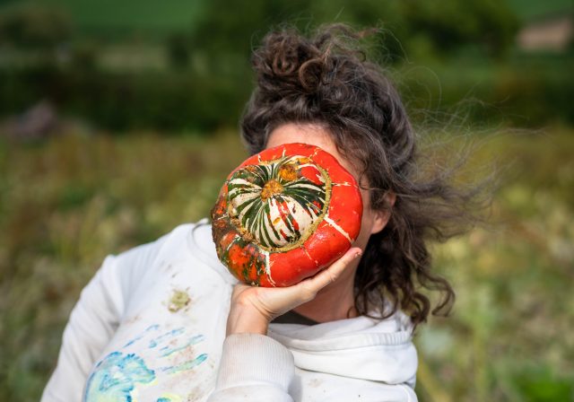 Woman holding a squash in front of her face (Photo by MAH Photographs)